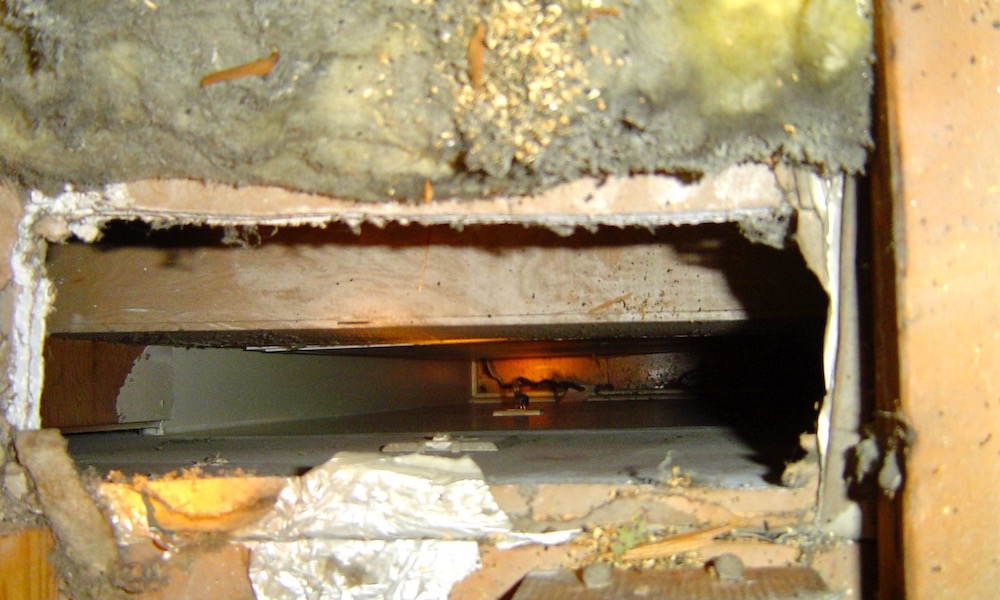 Air leakage site in an unconditioned attic. This hole was cut to be a vent for the heat from the refrigerator.