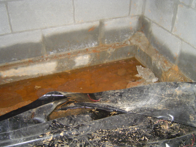 Standing water in a crawl space with poor drainage