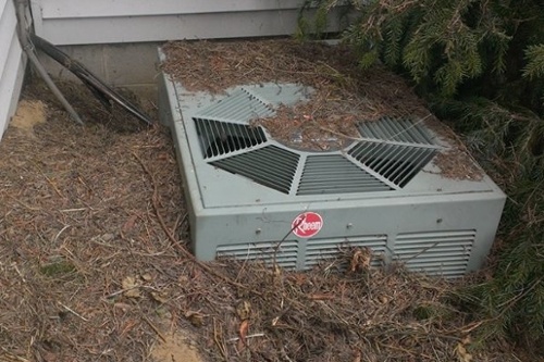Air conditioner outdoor unit buried in mulch