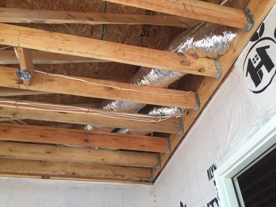 Two ducts travel through unconditioned attic above the porch.