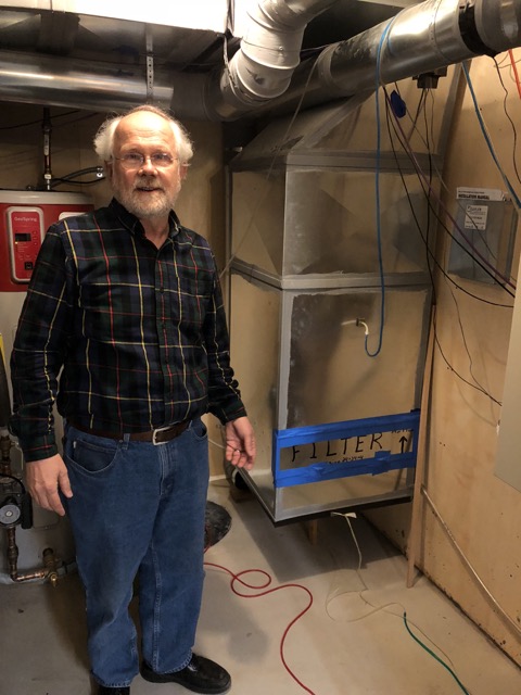 Gary Nelson站在他的18K富士通管道旁边的迷你分体式热泵