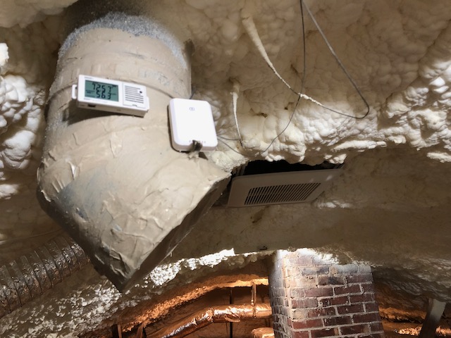 HOBO data logger near the ridge of a spray foam attic, with the exhaust fan nearby