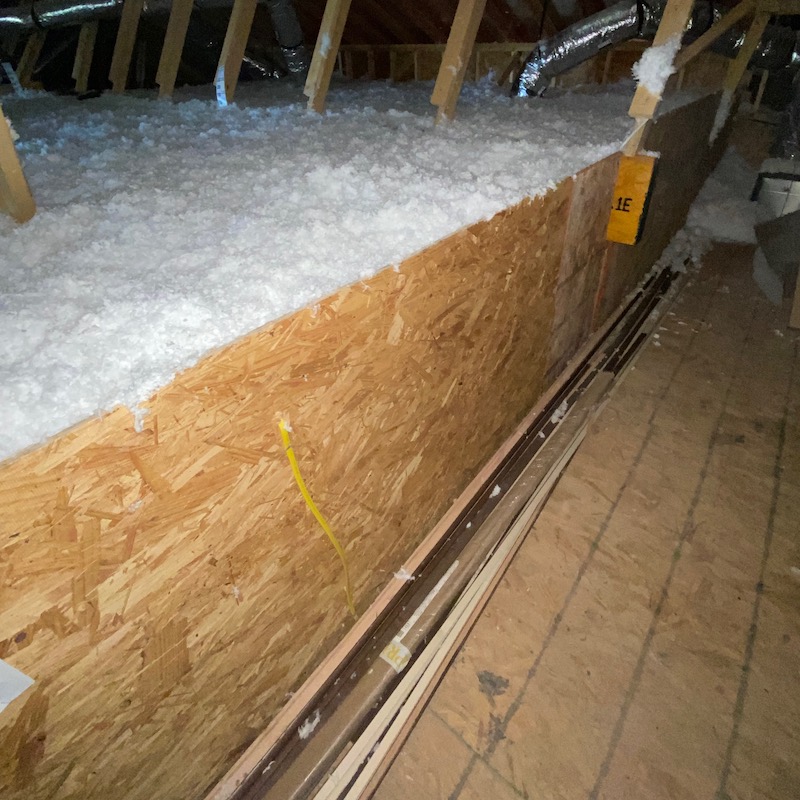 An attic kneewall sheathed with OSB and extended upward to create an insulation dam [Photo credit: Dave Yelovich, Tilson Homes]