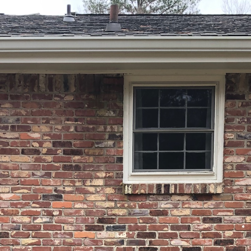 The bricks beneath another low roof penetration also show signs of water damage.