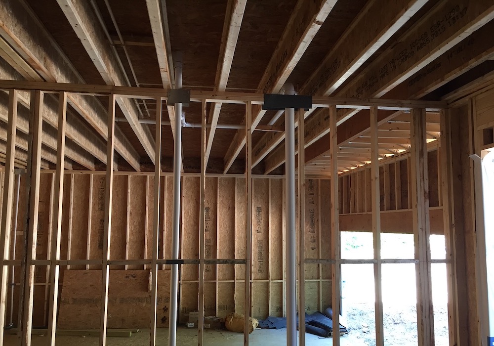 Open joists above wall between garage and living space