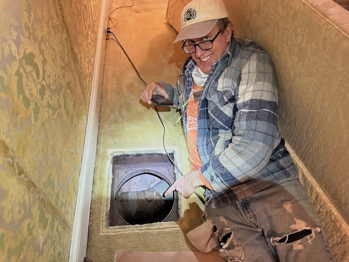 Mike Barcik of Southface points to a huge hole in the air barrier in this project of weatherizing an old house for the 2024 Martin Luther King Jr. Service Project