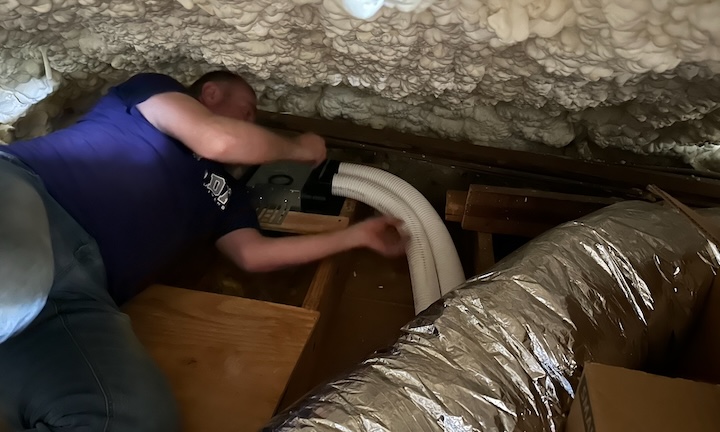 John connecting Comfotube to register box in attic