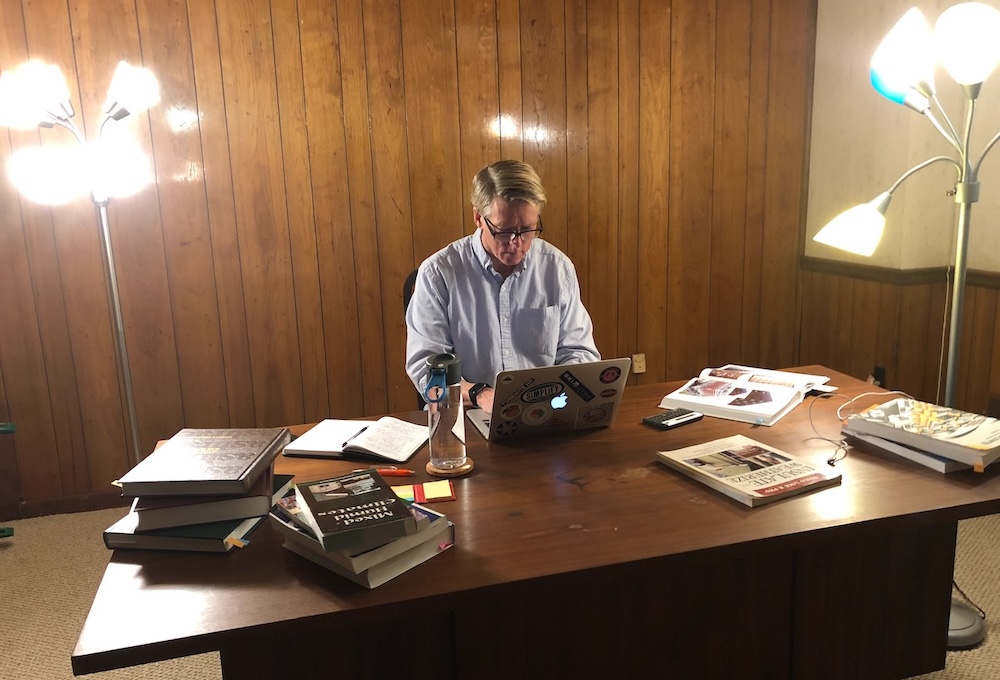 Allison Bailes writing his first book in basement with moldy wood paneling